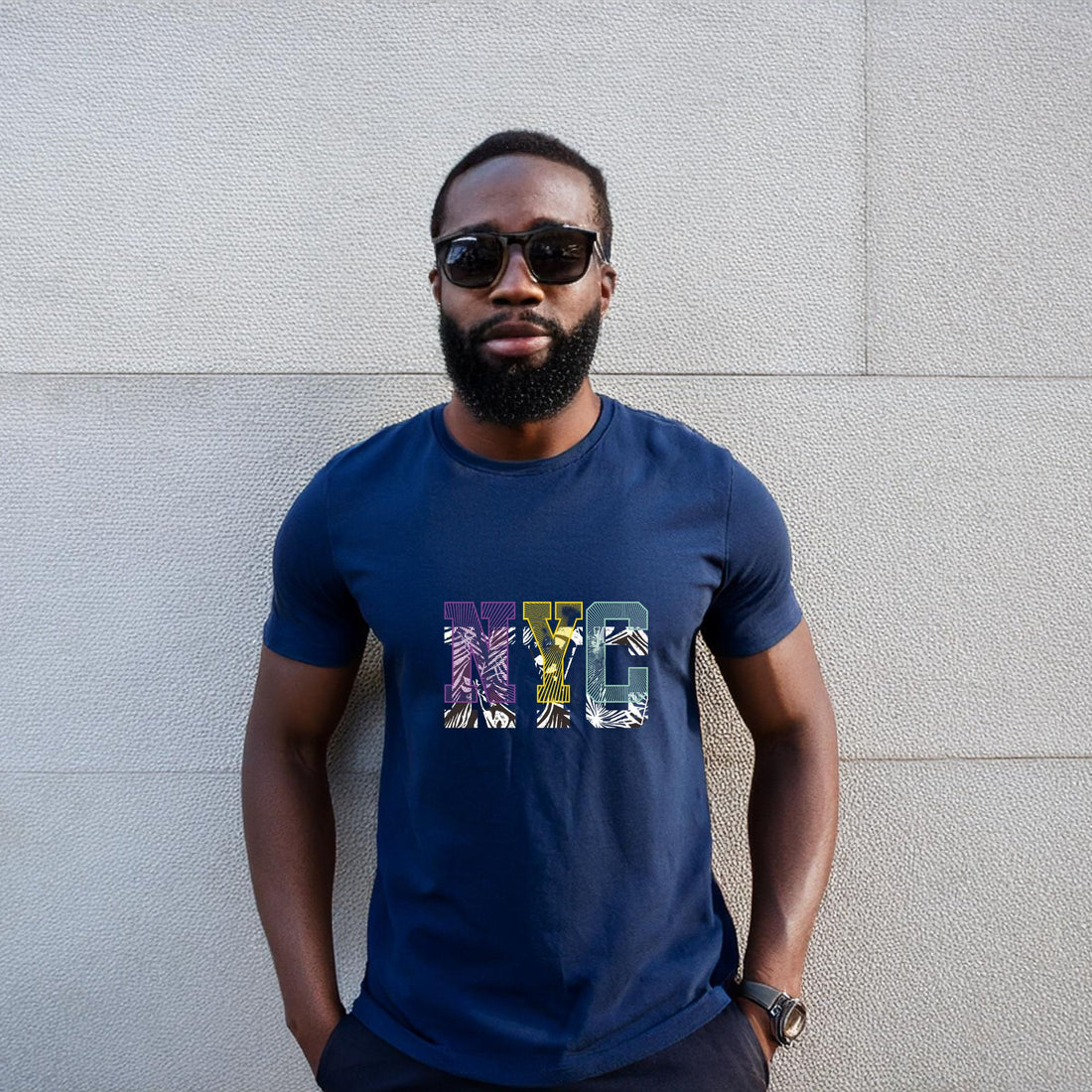 Man wearing a navy blue t-shirt with a colorful NYC graphic design in an urban setting.