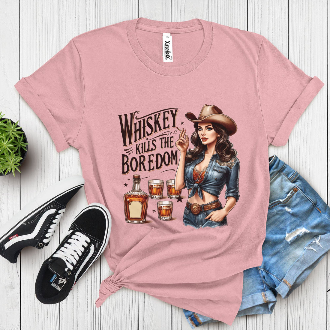 Western-style gray t-shirt with vintage cowgirl, whiskey bottle, and shot glasses illustration – "Whiskey Kills the Boredom" design