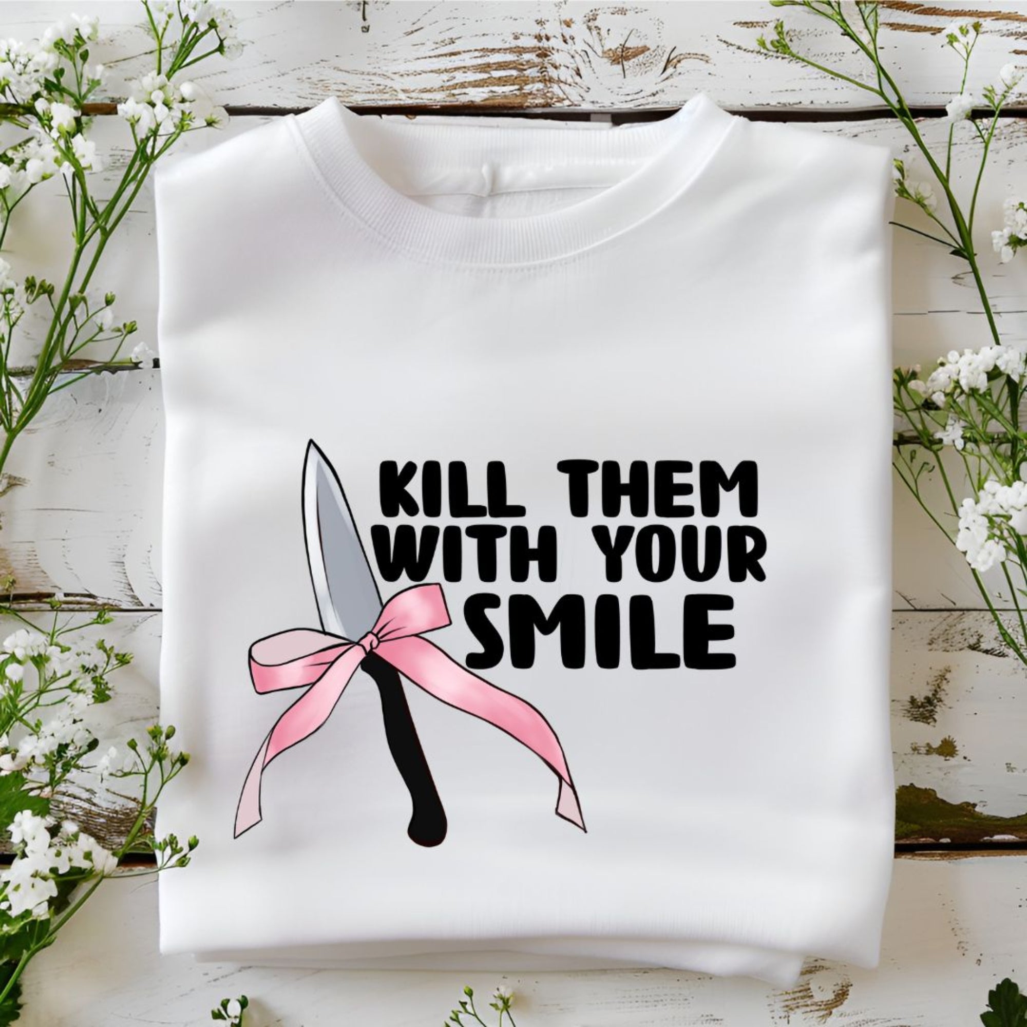 Bold white sweatshirt featuring 'Kill Them with Your Smile' graphic with a knife and pink bow. Cozy and edgy design for women