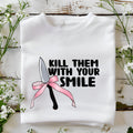 Bold white sweatshirt featuring 'Kill Them with Your Smile' graphic with a knife and pink bow. Cozy and edgy design for women