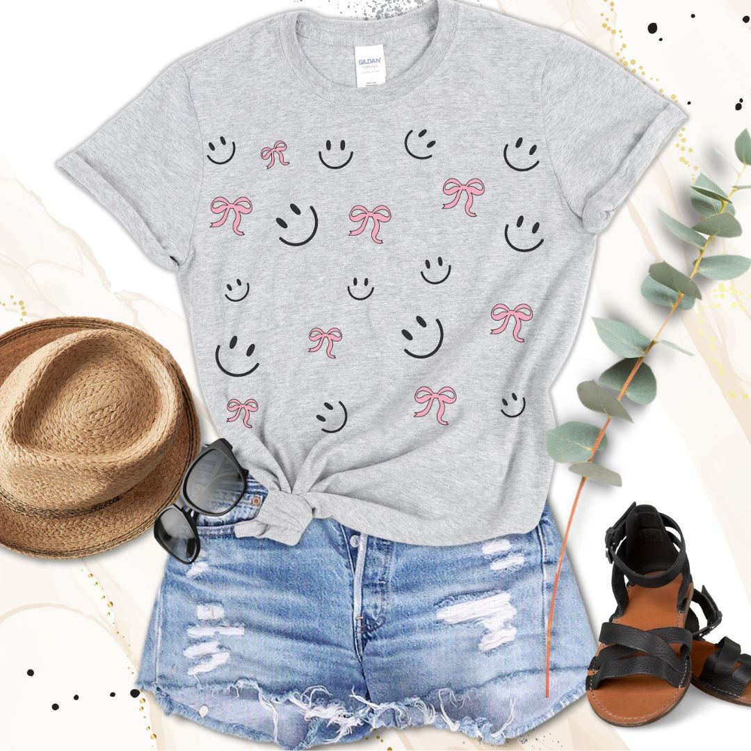 "Cute Smiley & Bow Graphic T-Shirt in gray, paired with ripped denim shorts and sandals. Trendy aesthetic outfit."